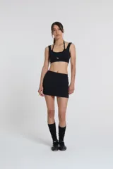 Top deportivo negro con doble escote superpuesto, cintura con elásticos de 3cm y compresión media.