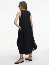 Vestido midi negro de silueta balloon con bolsillos laterales y mezcla de texturas en laterales y frente.