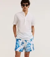 Bermuda de baño masculina en microfibra blanca con estampado de caracolas en tonos azules. Cuenta con cintura elástica ajustable con cordón y bolsillos laterales.