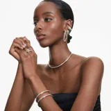 Anillo Swarovski Hyperbola con diseño torcido de tres bandas en mezcla de baño en tono oro y baño de rodio, adornado con Swarovski Zirconia en talla redonda y cuadrada con engaste de garra.