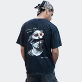 Remera negra con efecto gastado y logo 'Relajo' estampado en el pecho.