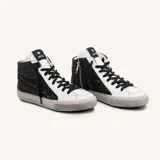 Zapatillas de caña alta de cuero vacuno blanco con glitter negro en los laterales y estrella de cuero negro. El interior es de cuero y la suela de caucho cosida.