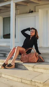 Bolso tipo hobo de cuero en tono dorado metalizado, con diseño amplio y flexible. Cuenta con doble correa de hombro, cierre superior y herrajes metálicos.