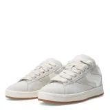 Zapatillas deportivas negras con detalles en blanco, suela blanca y base marrón.
