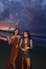 Falda larga tejida color vino tinto con brillo dorado, de corte ajustado y abertura lateral en la pierna.