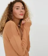 Buzo de punto negro de algodón, con cuello redondo y mangas largas.
