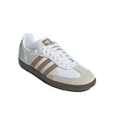 Championes Adidas Samba Og color blanco con detalles en marrón y suela de goma marrón. Presentan las tres tiras características de Adidas en los laterales y puntera de gamuza color beige.