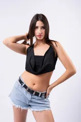 Top negro ajustado con escote drapeado tipo cowl neck y cuello halter. La tela presenta pequeños apliques brillantes distribuidos por toda la superficie.