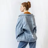 Campera de jean celeste con roturas en el frente y en la manga.