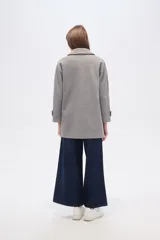 Tapado de poliéster color gris con cuello de solapa y cierre frontal de botones. Cuenta con mangas largas y un diseño de corte recto.