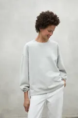 Buzo color gris claro de algodón orgánico y reciclado, con cuello redondo y mangas largas.
