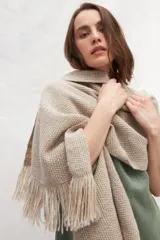Chal de tejido liviano confeccionado en lana 100% sin teñir, color marrón, con detalle de flecos en los extremos.