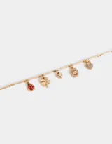 Pulsera dorada con cadena de eslabones rectangulares y dijes colgantes: mariquita roja, trébol de cuatro hojas, corazón pequeño, herradura y candado con forma de corazón.