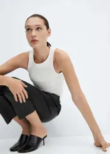 Pantalón negro de efecto piel, corte recto, tiro medio y cintura elástica con cordón ajustable.