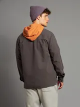 Camisa de corte clásico, de color gris oscuro, con botones frontales y bolsillos laterales.