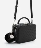 Bolso transversal tipo camera bag, color negro, hecho en material sintético texturizado. Tiene correa fina ajustable y removible, cierre por cremallera y colgante pompón.