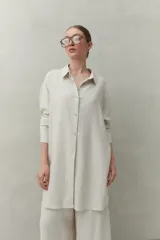 Vestido camisero corto negro de lino con botones tipo mostacillas y cinturón estampado.