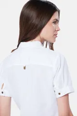 Camisa blanca de lino y algodón, con cuello clásico, mangas cortas y cierre frontal parcial con botones.
