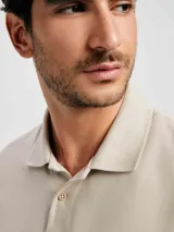 Camiseta tipo polo de manga corta, color azul oscuro, con cuello y tapeta de dos botones.