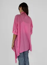 Camisola blanca con bordado calado, mangas 3/4 y corte asimétrico.