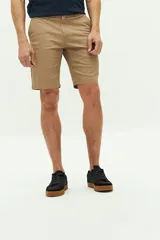 Bermuda color beige de gabardina, corte chino, con logo bordado, bolsillos laterales y traseros, cierre con cremallera y botón, y presillas para cinturón.