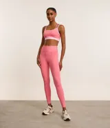 Calza deportiva larga color rosa, confeccionada en microfibra, con cintura alta con elástico porta remera y bolsillo lateral.