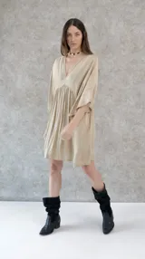 Vestido corto color beige, de raso, con escote en V y mangas 3/4. Corte holgado.