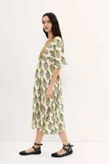 Vestido largo color crudo con estampado floral, escote en V, mangas 3/4 y detalle de frunces en la cintura.