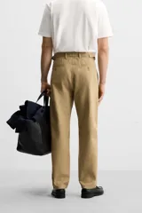 Pantalón chino color beige de corte recto, con cintura ajustable con cordón interior y trabillas laterales. Tiene bolsillos frontales y traseros de vivo.
