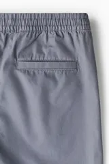 Short gris de lona de algodón, con cintura elástica ajustable con cordón, bolsillos laterales y bolsillo trasero.