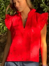 Camisa roja con bordado calado, cuello mao con volados y mangas cortas con volados.