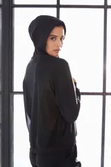 Campera deportiva negra con capucha y cierre frontal.