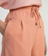 Short de poliéster color salmón con cintura elástica, cordón de ajuste, bolsillos laterales y pliegues frontales.