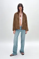 Cazadora marrón de piel con cuello solapa, manga larga, bolsillos de parche delanteros y cierre frontal con botones.