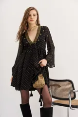 Vestido corto negro con estampado de lunares dorados, escote en V con bordado dorado, mangas largas acampanadas y forro interior. Confeccionado en viscosa jacquard con lurex.