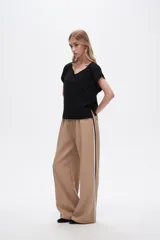 Pantalón negro ancho de viscosa con vivos laterales en blanco, dorado y marrón.