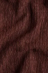 Pantalón marrón de punto con textura arrugada, corte holgado, tiro alto, cintura elástica y piernas rectas.