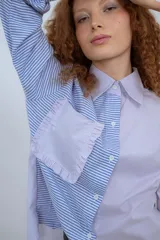 Camisa de algodón con diseño de rayas en tonos azul y lila, con voladitos en el bolsillo.
