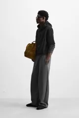Pantalón jogger wide fit color gris oscuro, confeccionado en tejido de algodón compacto con elasticidad. Cuenta con cintura elástica ajustable con cordón, pliegues frontales, bolsillos delanteros y bolsillo trasero de parche.
