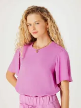 Blusa color rosado con mangas cortas abullonadas y cuello redondo.