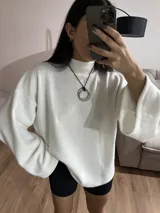 Sweater blanco de tela Aspen, cuello alto y mangas largas con puños acampanados.