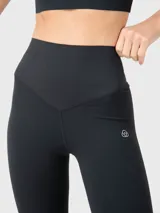 Calza deportiva negra de corte capri, con cintura alta y logo estampado en la pierna.