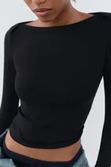 Camiseta negra de algodón con cuello barco y mangas largas.