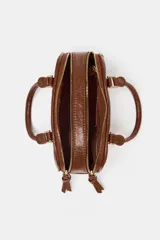 Bolso mini tipo bowling color negro charol, con doble asa de mano y correa bandolera extraíble. Tiene doble compartimento con cierre de cremallera y herrajes dorados.