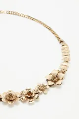 Cinturón plateado de metal con cadena de eslabones y apliques de flores.