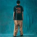 Remera negra de corte recto con estampado de un autobús escolar en el centro del pecho.