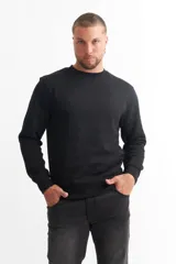 Buzo negro de algodón, cuello redondo y mangas largas.