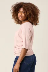 Blusa color rosa claro de hilo con textura acanalada horizontal, escote bote y mangas 3/4. Corte holgado.