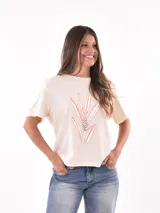 Remera color crudo con estampado de hojas en tonos naranja y gris.