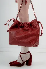 Cartera tipo bolso capitoneada de cuero color rojo, con asa de cadena plateada entrelazada con cuero. Forrada por dentro y con bolsillo interno.